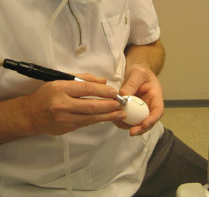 Tannlegen øver på transplantasjon av kjeveben på et egg, som krever en stødig hånd.